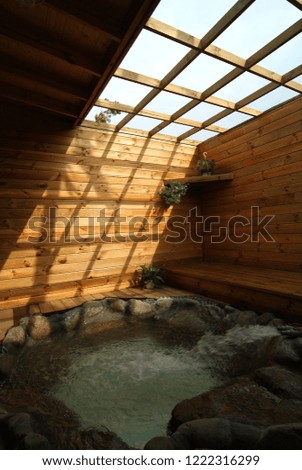 Brown wooden house, semi-outdoor interior and South Sea style spa bath.