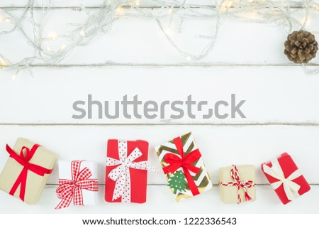 Christmas New year theme decorated red and craft gift box ribbon bow with sparkling light on white wooden table background with copy space for text.Displaying picture.