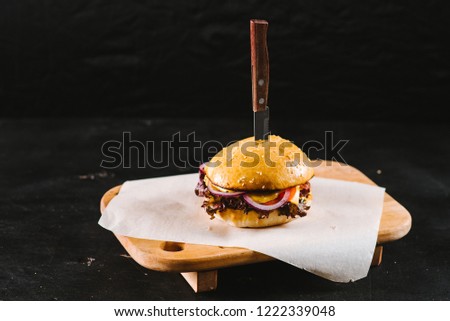 Tasty fast food burger on black background