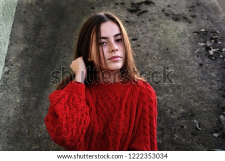 Teenage girl in red sweater on the grey background