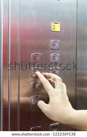Close-up of blind person finger reading braille on elevator lift panel