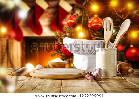 Cook hat on table and free space for your decoration. Christmas background of tree and fireplace. 