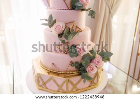 Beautiful wedding cake decorated with flowers. Pink color of cake. Powder rose