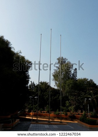 three of flagpoles at the park Royalty-Free Stock Photo #1222467034