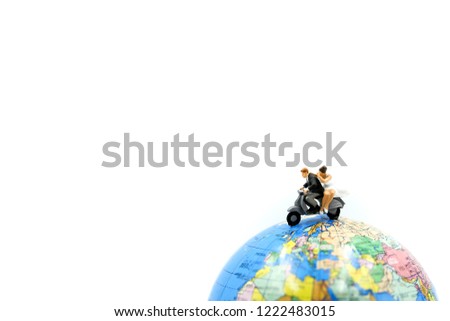 Miniature people : a newlywed couple riding the motorcycle on wolrd background for their honeymoon.