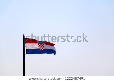 Flag of Croatia, blowing in the wind. Sky in the background, selective focus.
