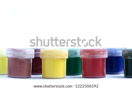 multi-colored cans of gouache in a row on a white background