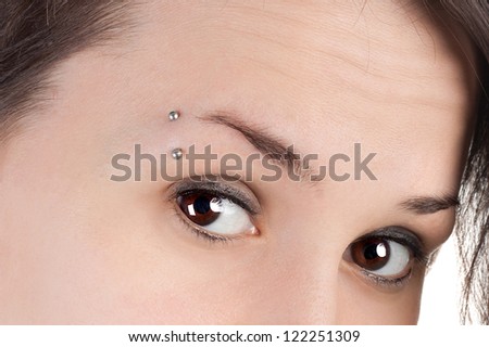 pretty young teenage girl with the piercing in the eyebrow, closeup