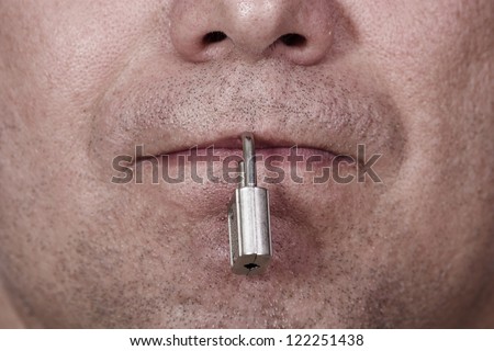 The mouth is closed with a padlock. The symbol of silence and censorship.
