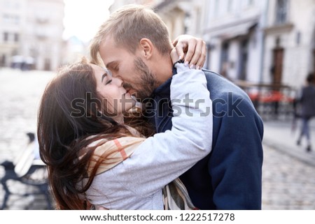 Portrait of a young romantic enamoured couple hugging and kissing during the city walk. Enjoying spending time together at the warm autumn day. Two lovers are walking, hugging and kissing in Lviv Royalty-Free Stock Photo #1222517278