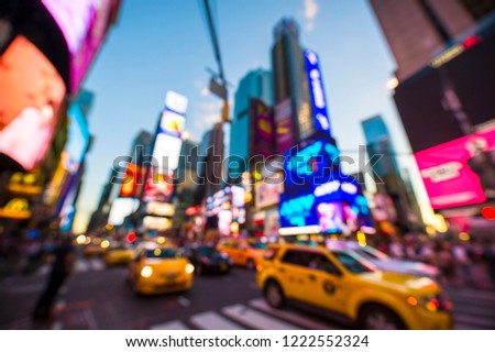 Abstract defocus view of the bright neon lights and traffic of Times Square under dusk skies in New York City, USA