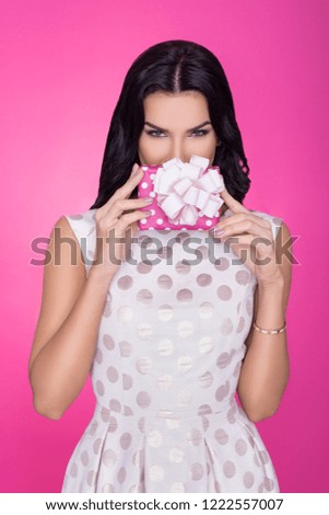 Beautiful women in pink background with present. Party. Love. Gift.