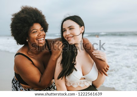 Cheerful beautiful plus size women at the beach