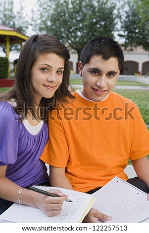 Portrait of two friends writing notes in college campus