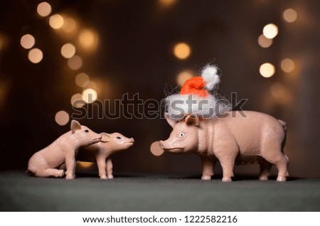 toy pig in Santa's cap on bokeh background