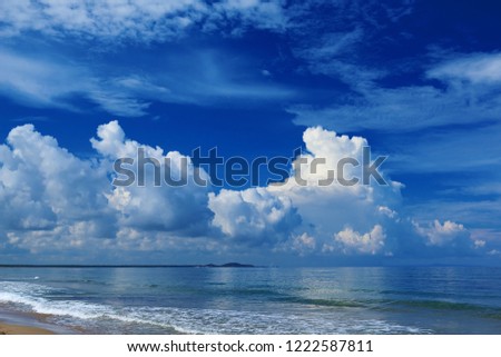 Beautiful romantic navy blue sky with amazing white clouds, sand beach of the blue sea. Beautiful summer sky and blue sea