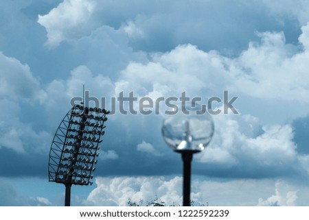Spotlight tower at the stadium with group clouds background