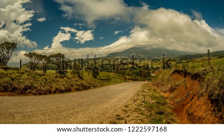 Landscape with dirt road and mountains at the bottom