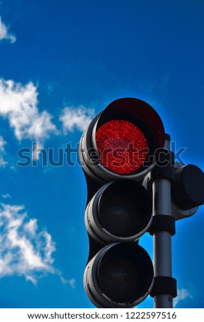 Traffic light with red lamp larger than the others. Red traffic light.