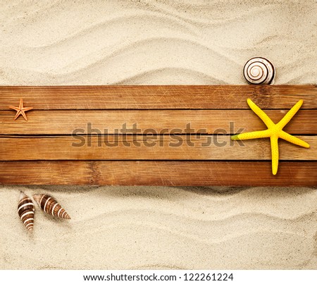 Few marine items on a wooden boards against sandy background.
