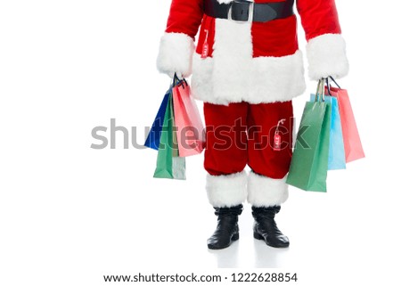 low section of santa claus in red costume with sale tags holding shopping bags isolated on white