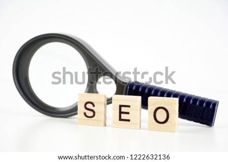 SEO, Search Engine Optimization word collected of wooden elements with the letters and also magnifying glass.