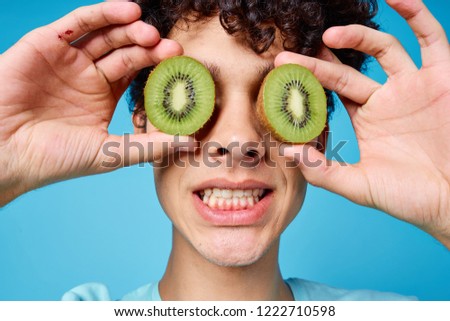 young man with slices of kiwi on the eyes                            