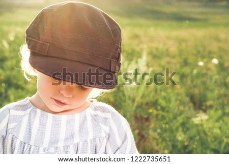 Funny pictures of a little girl. Portrait of a pretty little girl with a cap