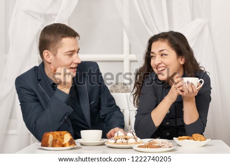 romantic couple drinking tea with cookies and talking