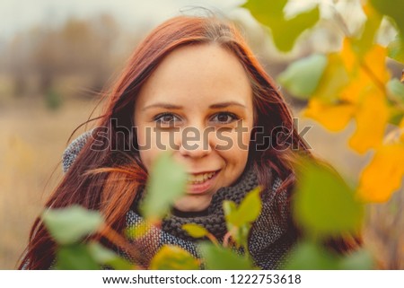 Girl on a background of yellow leaves of autumn trees. Autumn photo session. Autumn woman walking outdoors
