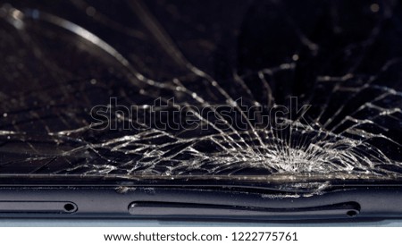 Close-up macro of broken dark glass. Elements of smartphone, screen, hammer blow, dropped smartphone