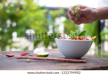 
Picture of a hand squeezing lemon into a food