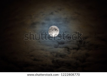 Black night sky with full moon concept of a spooky theme and mystery dramatic clouds