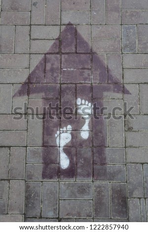 Arrow with floor tiles  and with footprints city graffiti top view