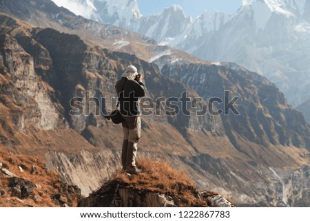 Tourist hiker taking picture of mountains in Annapurna basic camp. Nepal. Himalaya.