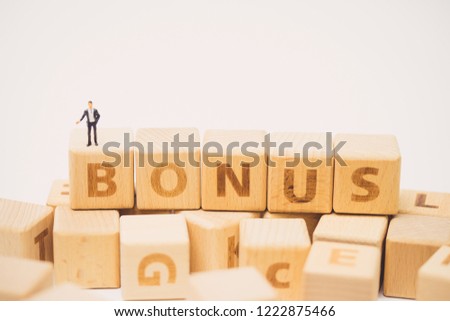Bonus word on wooden cube and miniature business man people.Concept for Bonus, Reward and Employee.