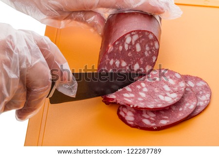 Cutting smoked sausage on the kitchen board