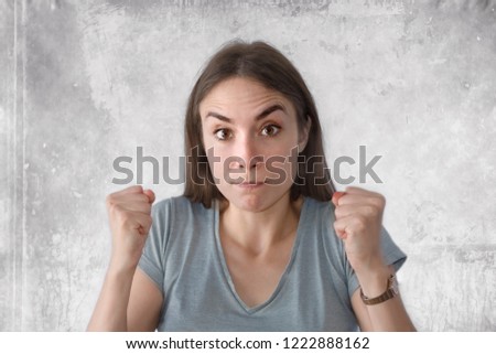 Young woman looking energetic with fists up