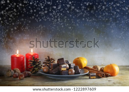 christmas cookies, tangerines, nuts and red candles on a rustic wooden table, starry sky with copy space, selected focus, narrow depth of field