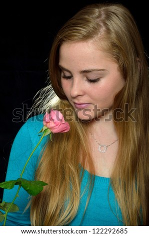 teen blonde girl with a rose on a black background