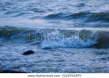 The texture of the waves of water. Out focus. Natural sea stones close-up.  Tourism and travel themed.
