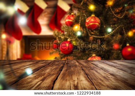 Table background of free space for your decoration. Christmas tree with balls. Fireplace background with few christmas sacks. Blurred lights decoration. 