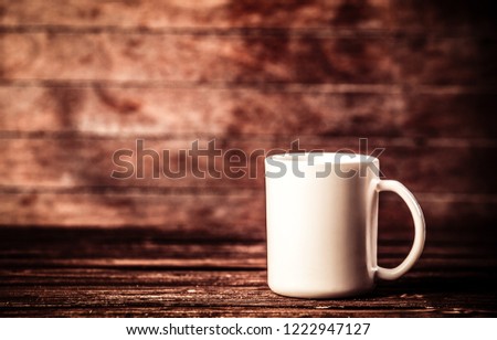 White cup of coffee on wooden table and background