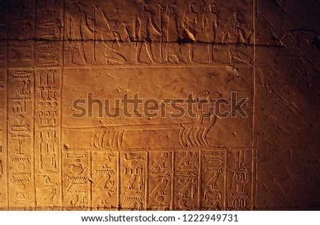 Ancient egyptian hieroglyphs carved on the stone wall 