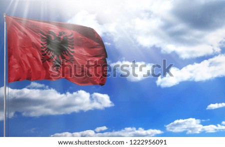 Flag of Albania on a flagpole against a blue sky, with a good place for your text.
