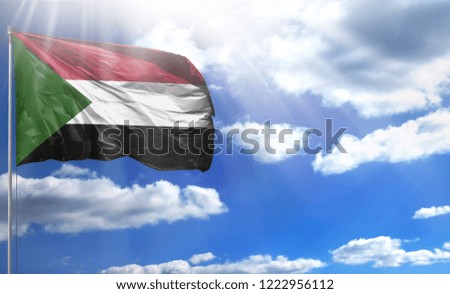 Flag of Sudan on a flagpole against a blue sky, with a good place for your text.