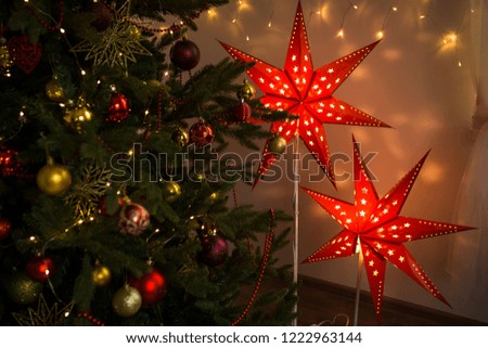 Red Christmas star. Christmas cozy home interior decoration, two glowing stars-Christmas home decorations for the New year