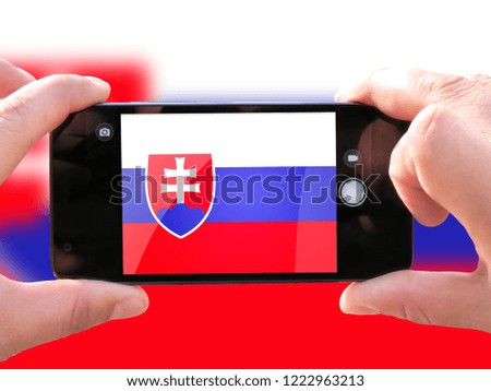 The concept of tourism and travel. The hands of men make a telephone photograph of the flag of Slovakia. On the smartphone close-up image of the flag. Photos for social networks, blogs, instagram.