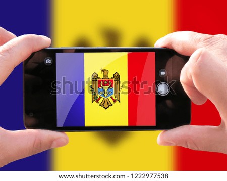 The concept of tourism and travel. The hands of men make a telephone photograph of the flag of Moldova. On the smartphone close-up image of the flag. Photos for social networks, blogs, instagram.