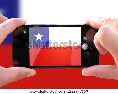 The concept of tourism and travel. The hands of men make a telephone photograph of the flag of Chile. On the smartphone close-up image of the flag. Photos for social networks, blogs, instagram.